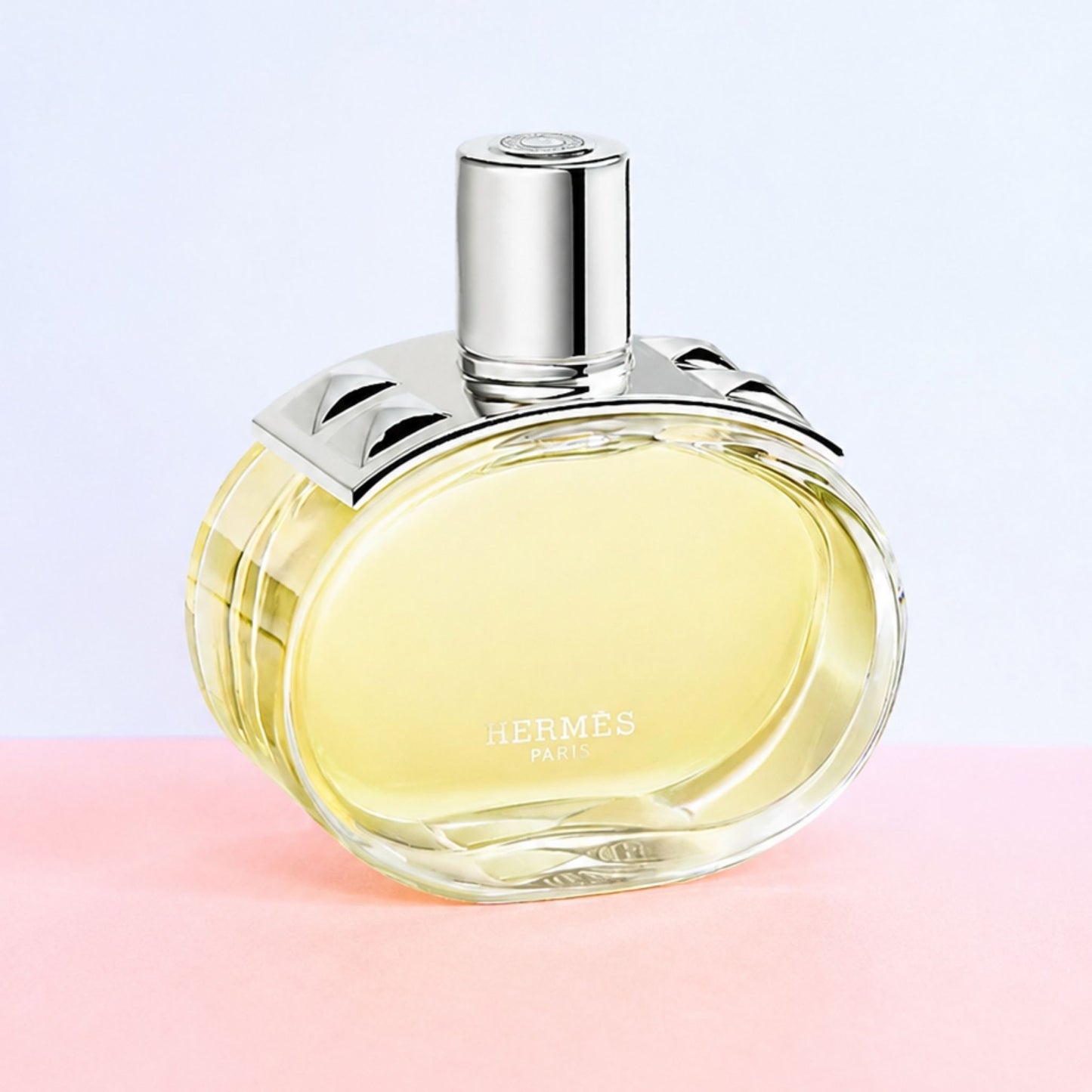 Authentic Hermes Barenia perfume bottle on pink and white background 