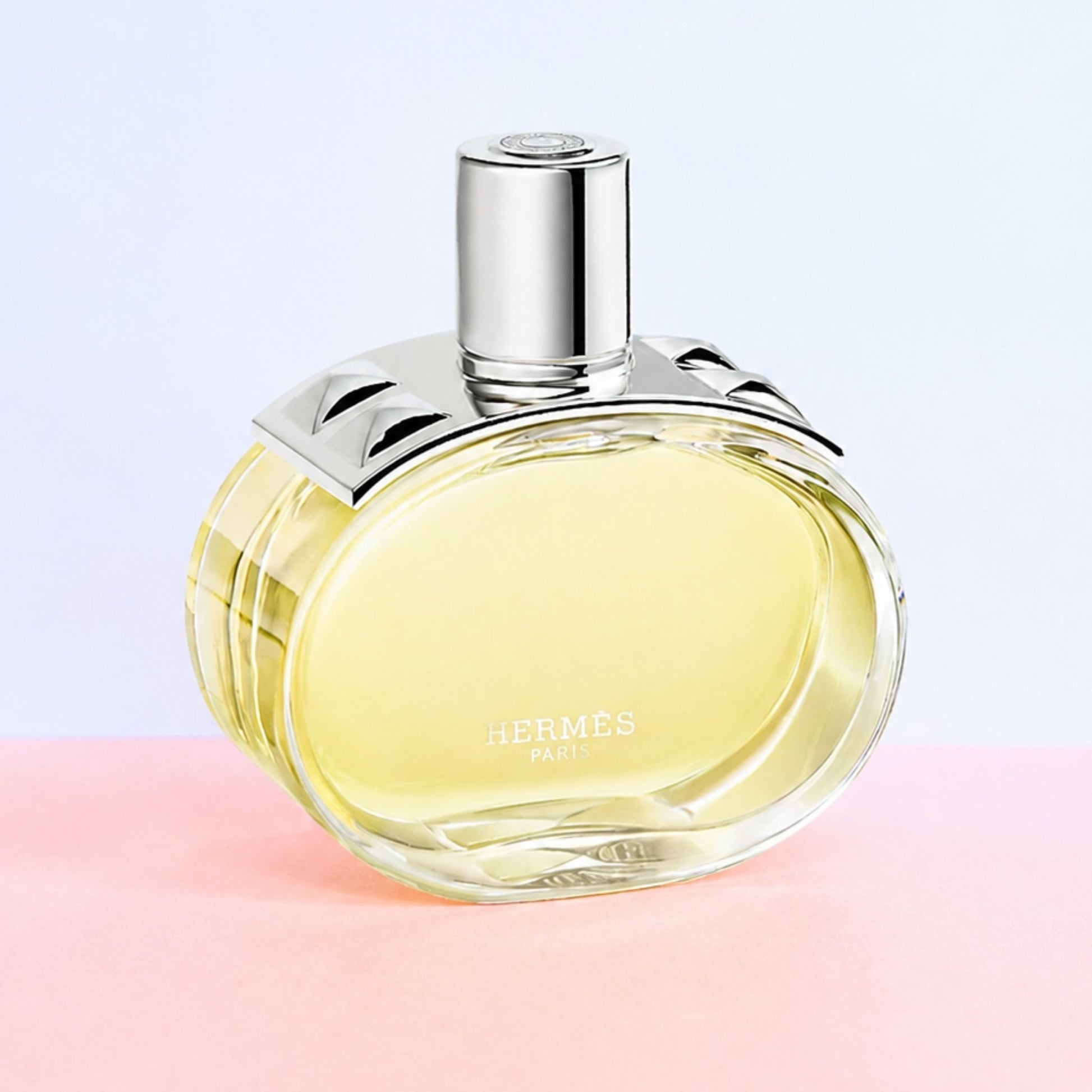 Authentic Hermes Barenia perfume bottle on pink and white background 